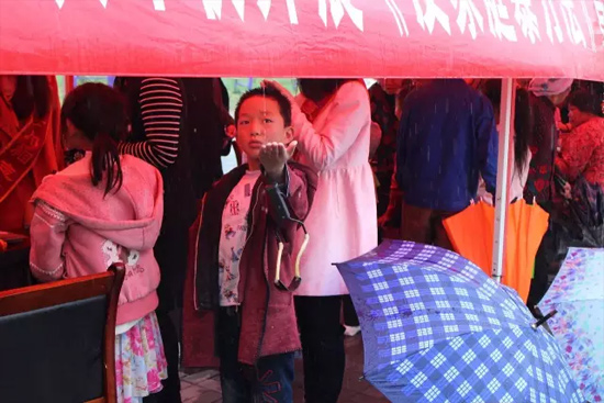 因?yàn)橛晗碌奶?，小男孩玩起了接水游戲? complete=