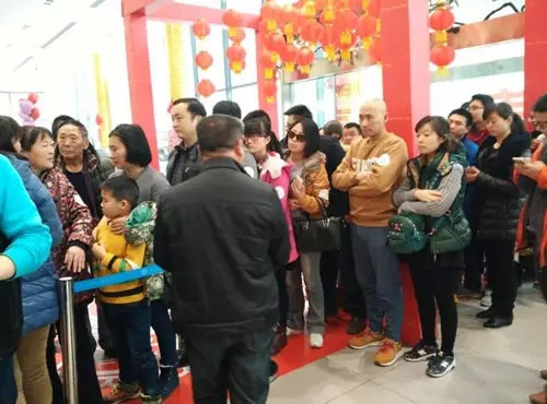 排隊(duì)領(lǐng)年貨，一家老小齊上陣。