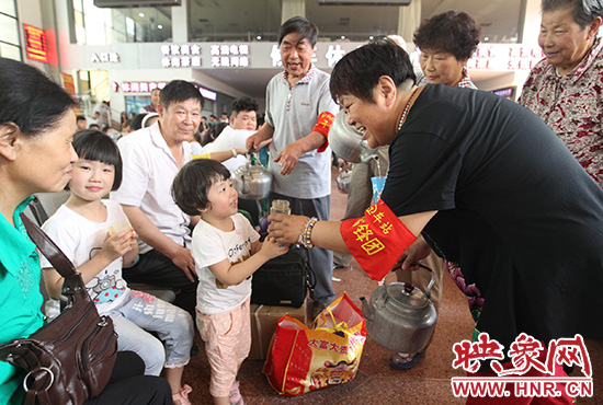 老年雷鋒團”志愿者在候車廳為旅客送水。