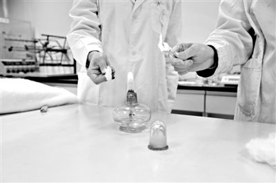 實驗人員操作的燃燒檢測法中，真蠶絲離開火焰就熄滅(左)。