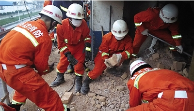 消防人員在清理熔鹽爐倒塌的廢墟。