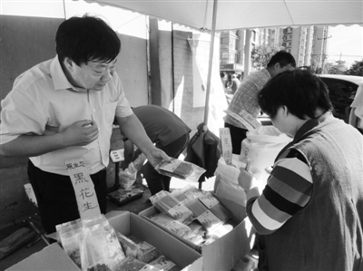 昨日，河南企業(yè)家劉春喜在京“練攤”，為顧客挑選綠豆。新京報記者 張玉學(xué) 攝