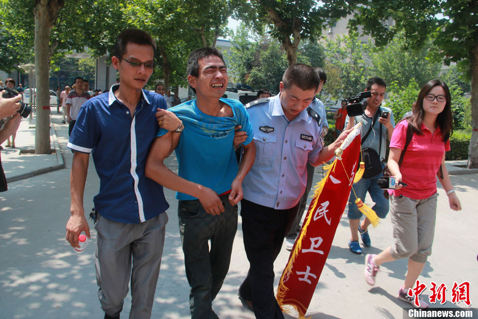 圖為獲救嬰兒父親情緒一度失控，當?shù)鼐焦ぷ魅藛T對其進行攙扶。張一辰 攝