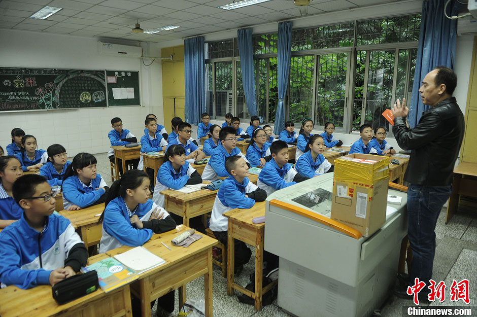 圖為老師正在向同學(xué)們講解用非智能手機對他們的好處。