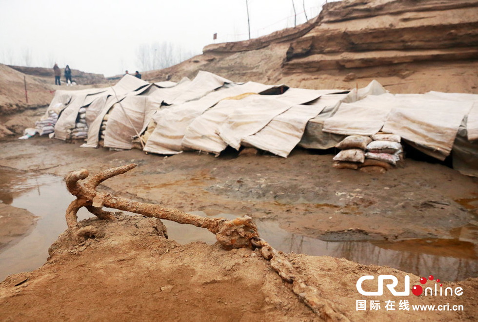 2014年1月6日，河南洛陽古沉船發(fā)掘現(xiàn)場，古沉船鐵錨從見天日，靜靜地躺在古船旁。