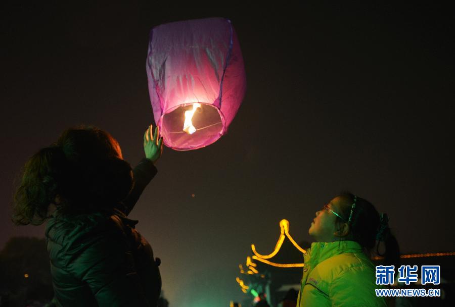 　1月30日，游客在江蘇省鎮(zhèn)江市金山公園門口放飛孔明燈。
