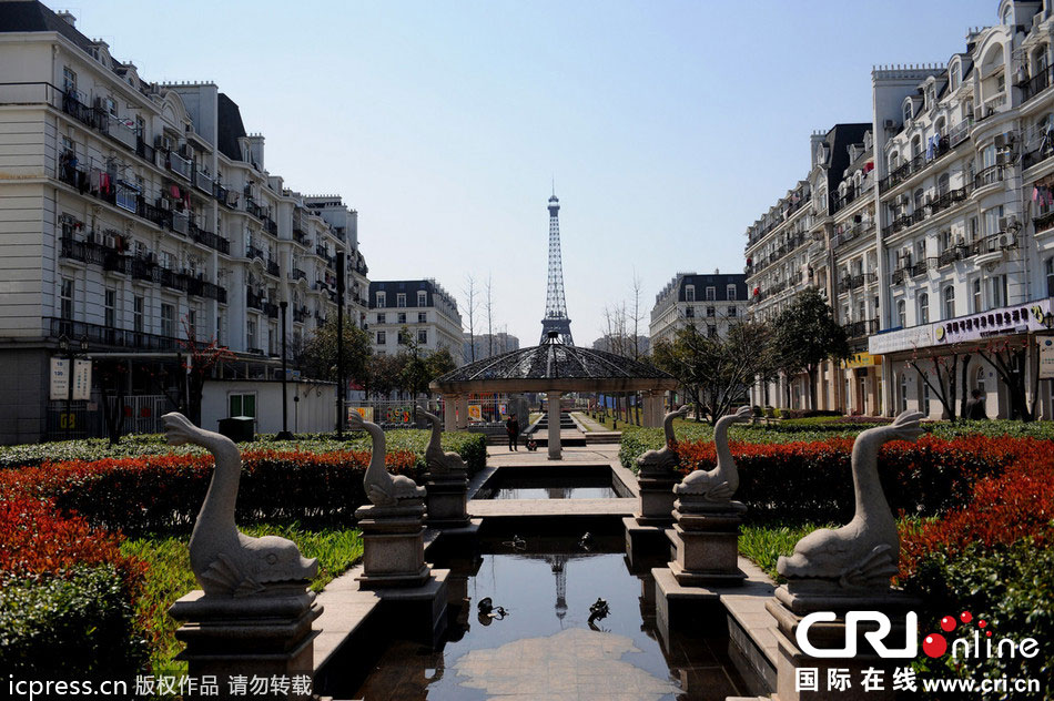 　2014年3月21日，杭州天都城，農(nóng)民在山寨埃菲爾鐵塔下耕作。圖片來(lái)源：東方IC