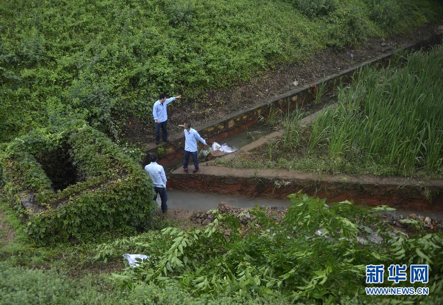 5月18日，工作人員在槽罐車泄漏現(xiàn)場(chǎng)附近的水渠邊查看情況。