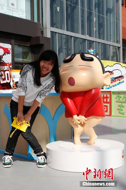 4月22日，游客與蠟筆小新合影?！跋灩P小新25周年紀(jì)念特展”日前在北京開(kāi)展，吸引了不少市民游客。