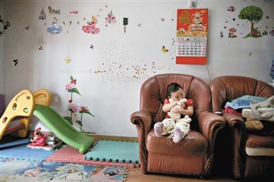 6月14日，未婚媽媽于軍的家里。女兒悅悅抱著兔子玩偶，在聽(tīng)媽媽手機(jī)上的兒歌，這個(gè)4歲女孩喜歡兔子。