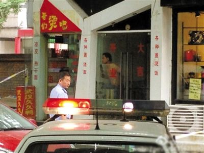 闖入面館的持刀男子與趕來的民警隔著玻璃門對峙，后店內(nèi)一名女童被其劫持。網(wǎng)友供圖
