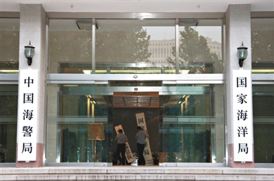 昨日，中國海警局掛牌成立。原國家海洋局和中國海監(jiān)總隊的牌匾被摘下，國家海洋局和中國海警局的新牌匾換上。黃冉 攝