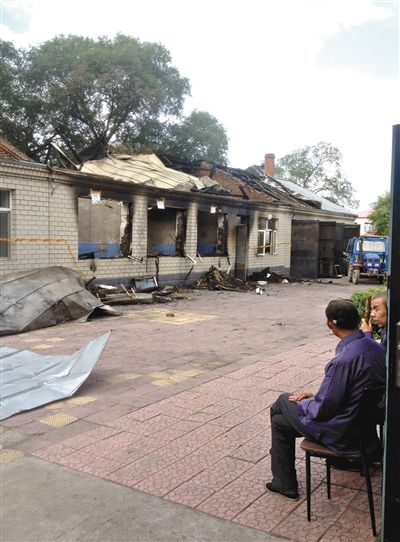 7月27日，海倫聯(lián)合敬老院內(nèi)，幾名老人看著對面被燒毀的特護(hù)病房。新京報(bào)記者 涂重航 攝