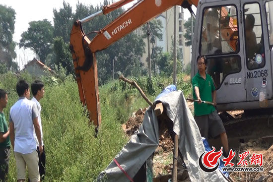 陳寶成手持自制刀斧守在挖掘機旁阻止便衣民警靠前。駕駛室內(nèi)，張朋珂正向受害人郭曉剛身上澆汽油。（視頻截圖）