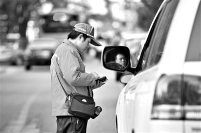 10月15日，朝陽(yáng)區(qū)東大橋路，停車管理員從腰間掏出一個(gè)專用POS機(jī)，正在錄入停車信息。新京報(bào)記者 周崗峰 攝