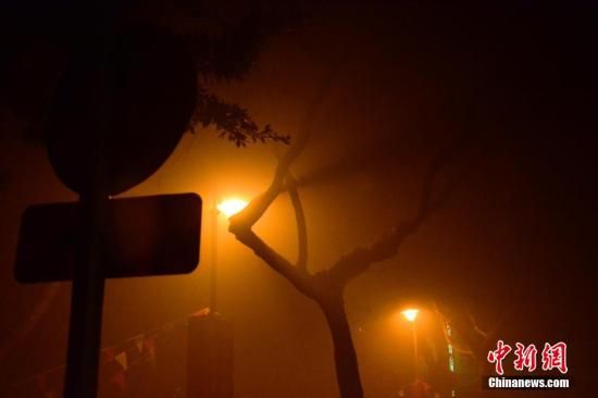 1月31日凌晨，市民行走在煙霧繚繞的南京街頭。當(dāng)天是農(nóng)歷馬年正月初一，南京有限開禁燃放煙花爆竹正逢下霧天，空氣的不流通致使煙花爆竹燃燒后產(chǎn)生的顆粒物不能及時(shí)散開，造成整座城市煙霧繚繞。據(jù)當(dāng)?shù)丨h(huán)保部門發(fā)布的信息顯示，空氣質(zhì)量屬重度污染。中新社發(fā) 泱波 攝
