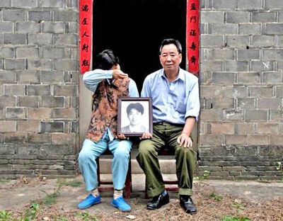 江蘇鎮(zhèn)江，老劉夫婦捧著獨(dú)生子的遺像在老家前留影南方都市報供圖L