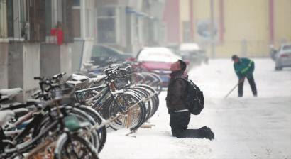 小伙子跪在樓前，一直抬頭看著樓上。 孫立國/攝