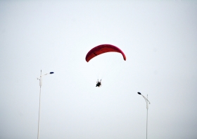 10月25日下午，動力傘從一對路燈上空飛過