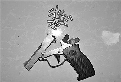 警方從搶劫嫌疑人處起獲的贓款和發(fā)令槍、子彈。警方供圖