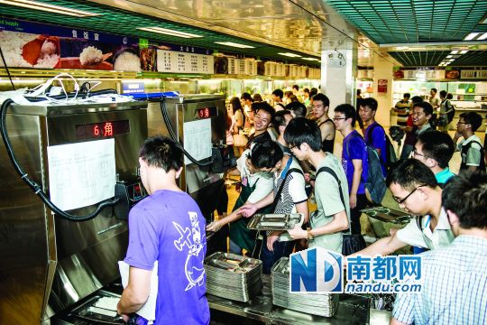 昨日，華南理工大學一食堂內(nèi)，學生們正在使用新安裝的自動打飯機打飯。中新社發(fā)