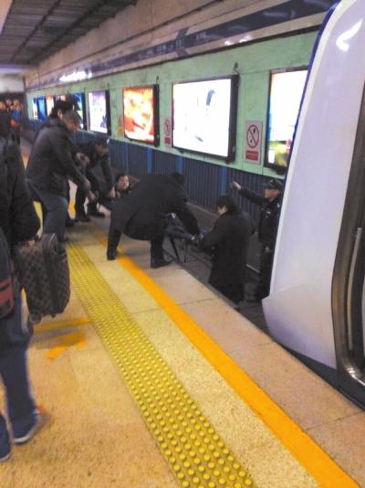 地鐵工作人員將林某從站臺下救起。網(wǎng)友供圖