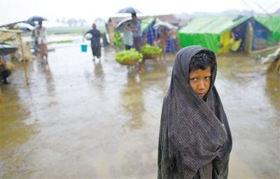 5月14日，緬甸若開邦實(shí)兌難民營(yíng)，羅興亞族難民在雨中行走。熱帶風(fēng)暴“馬哈森”即將登陸緬甸，這里的難民開始乘船撤離。