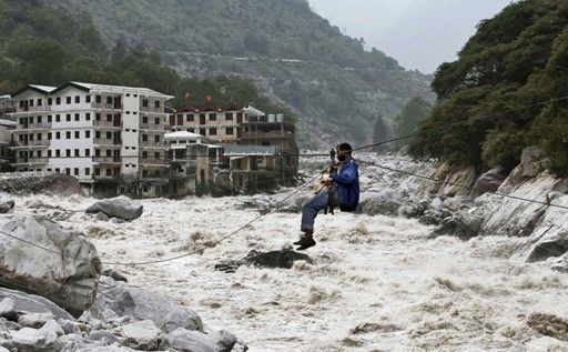 一名印度男子靠繩索渡河。