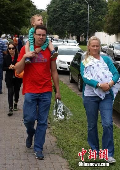 圖為一個白人家庭，由父母帶著孩子到曼德拉家門外悼念。中新社發(fā) 宋方燦 攝