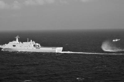 11日，抵達(dá)馬航飛機失聯(lián)海區(qū)的海軍井岡山艦與艦載直升機協(xié)同展開立體搜救行動。新華社發(fā)