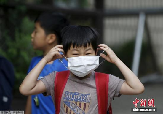 圖為當?shù)貢r間2015年6月8日，韓國未停課的學(xué)校，學(xué)生課前戴口罩測體溫。