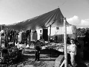 黎巴嫩一敘利亞難民營，難民支起攤鋪賣衣服掙錢。