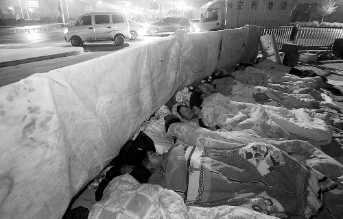 在寒冷的冬夜，為了能省點(diǎn)錢，方便接活，民工們?nèi)运跇蛳隆? complete=