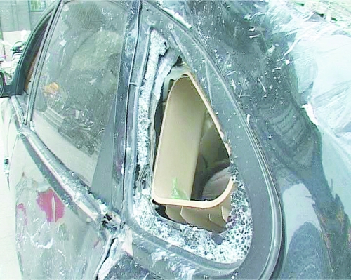 爆炸導(dǎo)致部分窗玻璃碎裂掉落,殃及樓下停放的轎車。