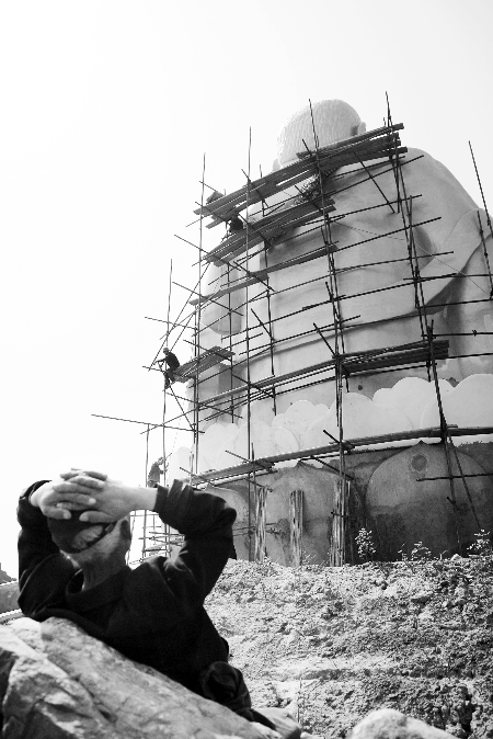 今年4月26日，工作人員將帆布蓋在“佛像”頭像上