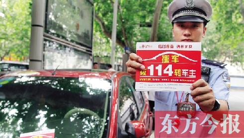8月27日，鄭州市緯一路與經(jīng)七路交叉口，交警將“挪車請(qǐng)撥打114轉(zhuǎn)車主”的提示牌放在路邊?？康能嚿? width=