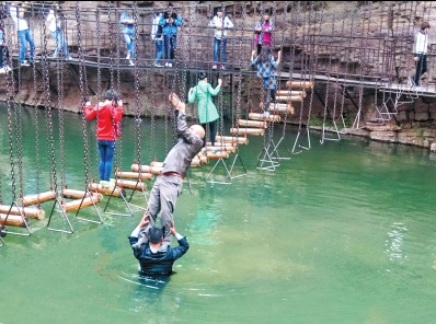 中年男游客正踩著景區(qū)安全員郭小明的肩膀過(guò)河。網(wǎng)友“@我的小名叫張孩”供圖
