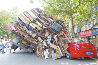 紅色小轎車被砸，卡在路邊動彈不得。