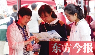 家長和孩子在高招咨詢會(huì)上咨詢學(xué)校信息