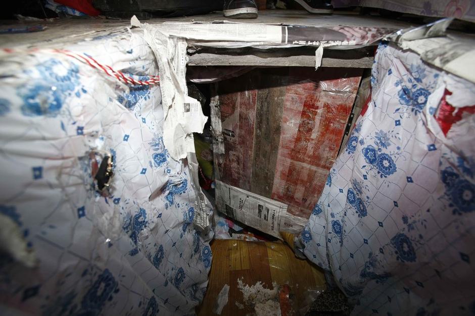 陳小龍?jiān)诔鲎馕萃?，自行又圍起一堵圍墻，安裝了一個(gè)門。圍墻上都是豎起的鐵釘，外面堆著土，鄰居猜是從地底挖出來的。洞口就在床邊，0.5米見方，深約1.5米。洞口表面一塊紙板掩蓋，打開紙板跳入洞底，是一扇小木門，木門外有插銷，可以從外面鎖上。