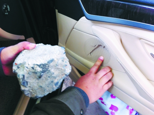 “飛”進(jìn)寶馬車內(nèi)的大石塊,將寶馬車的車門內(nèi)飾板砸爛。