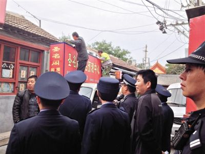昨日下午,東城區(qū)工商、城管、公安等部門(mén),對(duì)雍和宮附近的預(yù)測(cè)中心進(jìn)行清理整頓,站在車(chē)頂?shù)膬擅と苏鸪患摇邦A(yù)測(cè)中心”的招牌。因雍和宮、白云觀等文化景點(diǎn)外聚集大量算命先生,被媒體稱(chēng)為“算命一條街”。本版攝影/新京報(bào)記者 李寧 攝