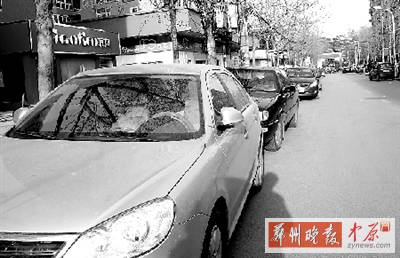 友愛(ài)路，路邊停了一排車(chē)，本來(lái)不寬的路就變得更窄了。