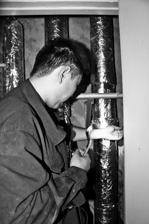 苗師傅一邊進行維修，一邊用耳機接聽市民的電話。