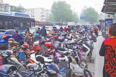 省人民醫(yī)院北門，路邊的公交站牌處停滿非機(jī)動(dòng)車，上、下客只能在快車道上。