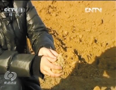 麻剛沙系麻剛石粉碎而成。記者找到一塊麻剛石，一捏就碎成粉末，硬度非常差。央視截圖