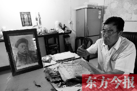 　魏樹紹手拿《物權(quán)法講義》手稿，在講訴先祖書寫“物權(quán)法”的歷史（相框里就是魏聯(lián)奎）