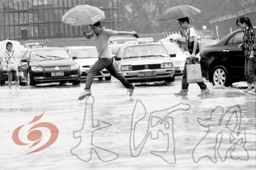 鄭州經(jīng)三路與北環(huán)交叉口處，積水較深，行人們不得不“練輕功”。 記者 白周峰 攝影