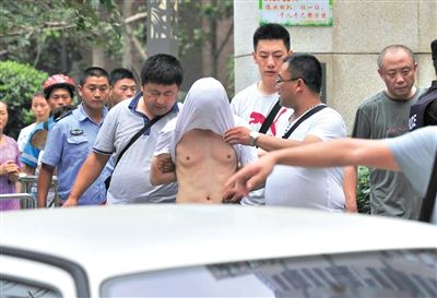 昨日，成都警方抓捕時與毒犯發(fā)生槍戰(zhàn)。一名男犯罪嫌疑人被警方押出。