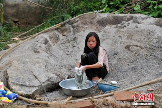 8月9日，云南巧家紅石巖村，10歲的劉鑫蕊在洗自己的衣服